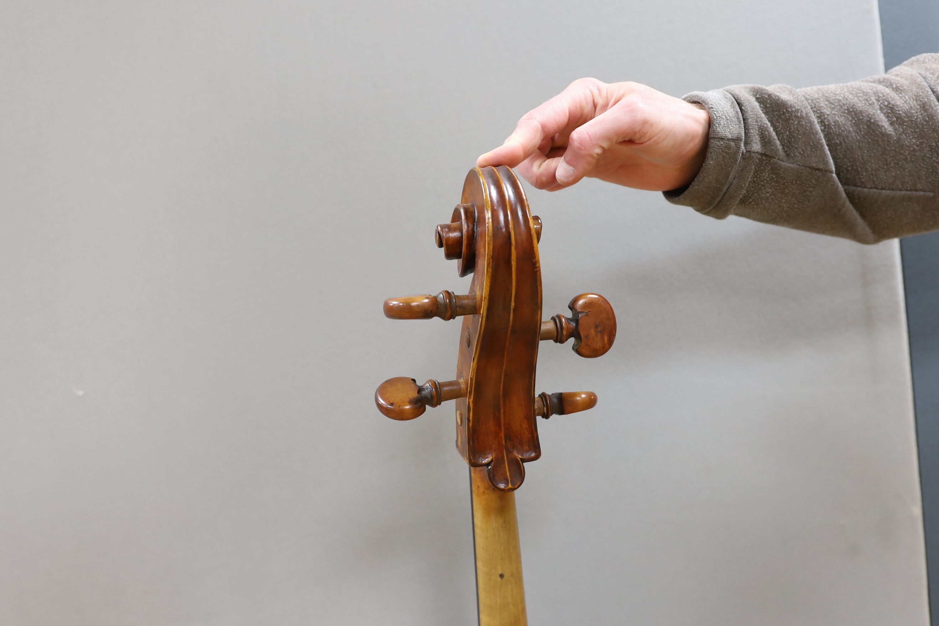 A cased early 20th century ‘cello, length of body 75.5cm, with two spare bridges, and spare strings